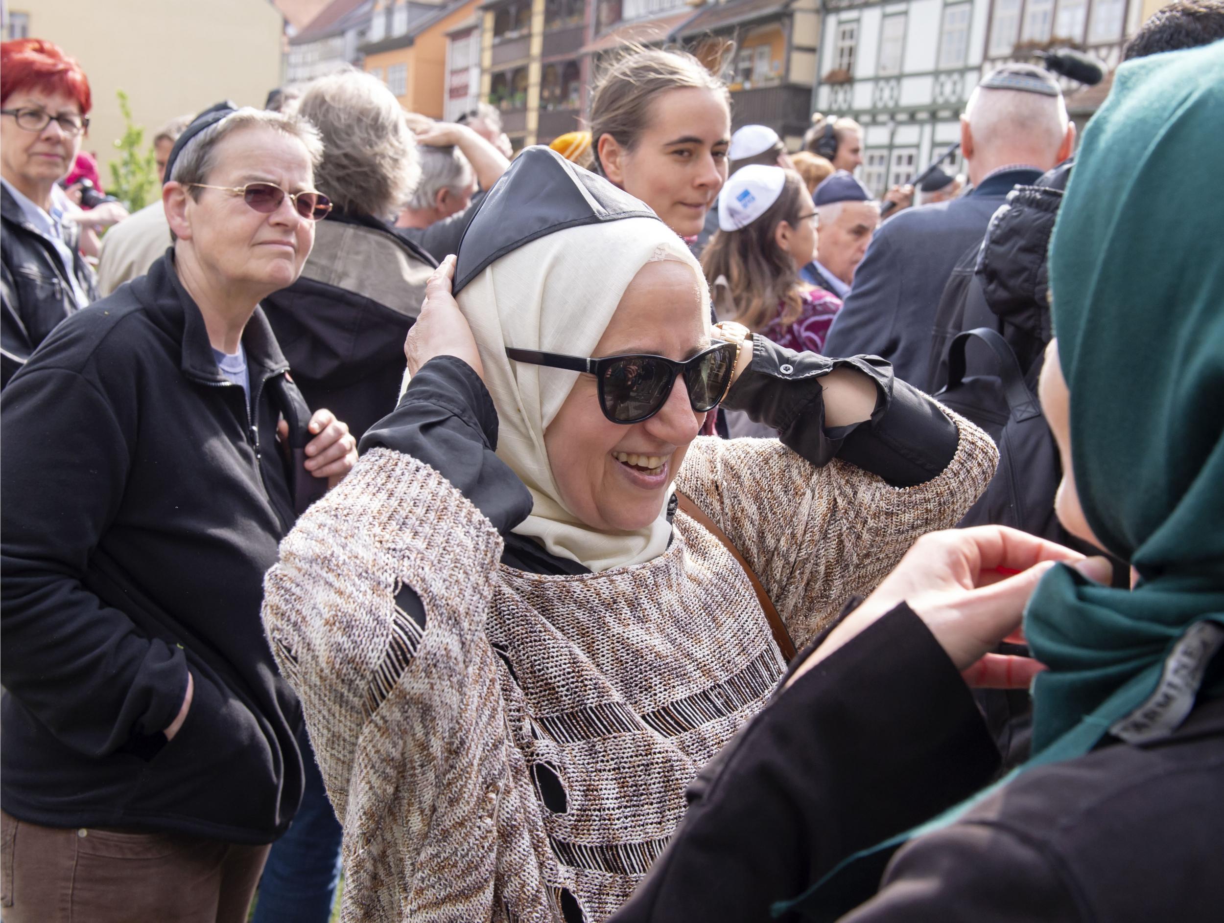 A Muslim woman wears the Kippah during a demonstration against antisemitism
