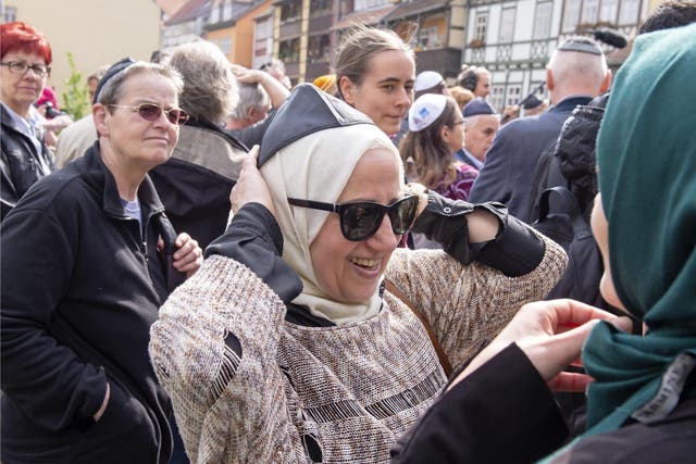 A Muslim woman wears the Kippah during a demonstration against antisemitism