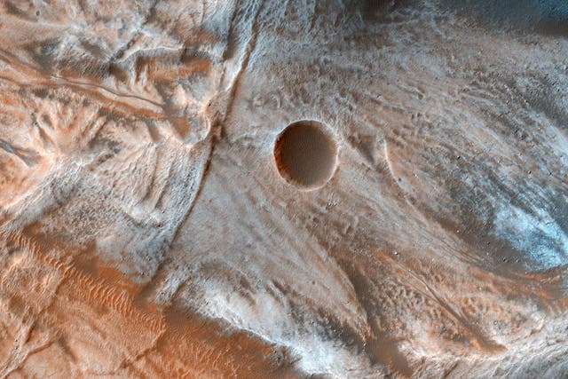 A view of the surface of Mars released by NASA on March 7, 2017, shows viscous, lobate flow features commonly found at the bases of slopes in the mid-latitudes of Mars, and are often associated with gullies