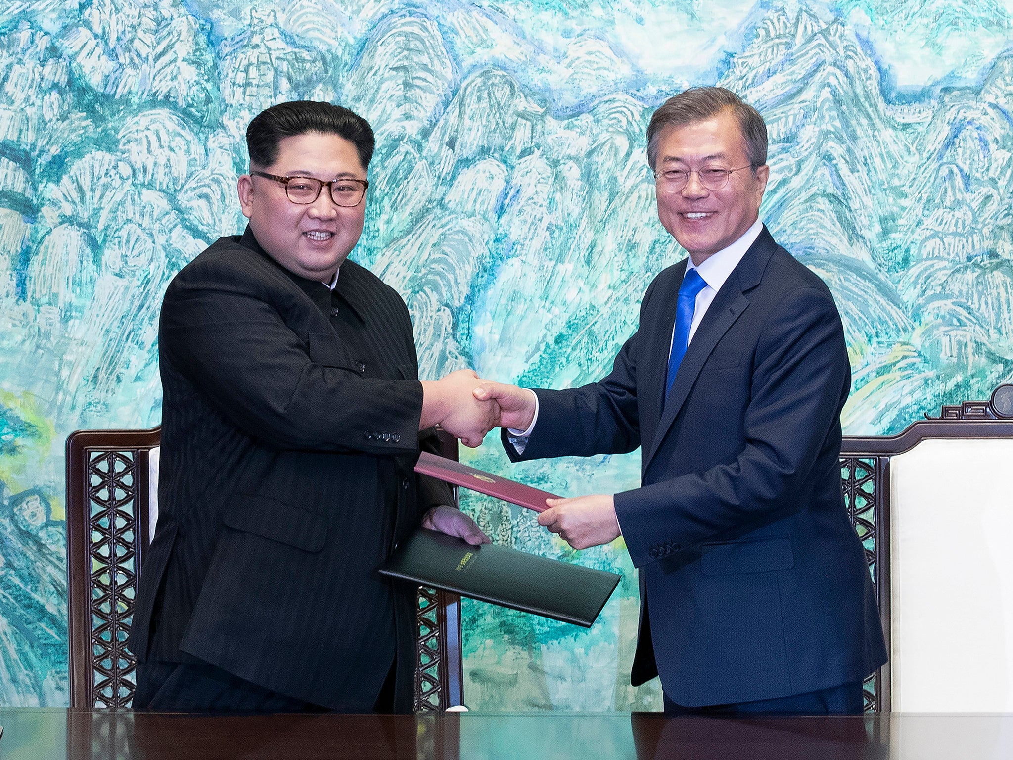 North Korean leader Kim Jong-Un exchanges a document with South Korean President Moon Jae-In