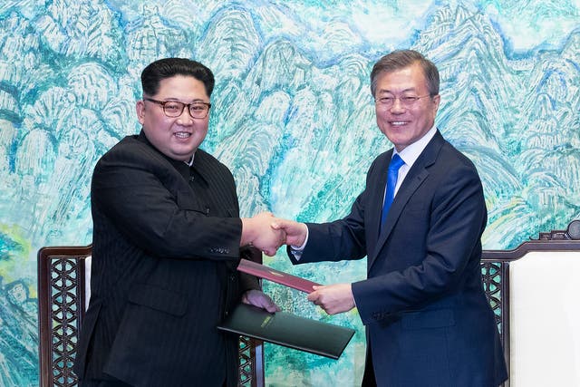 North Korean leader Kim Jong-Un exchanges a document with South Korean President Moon Jae-In