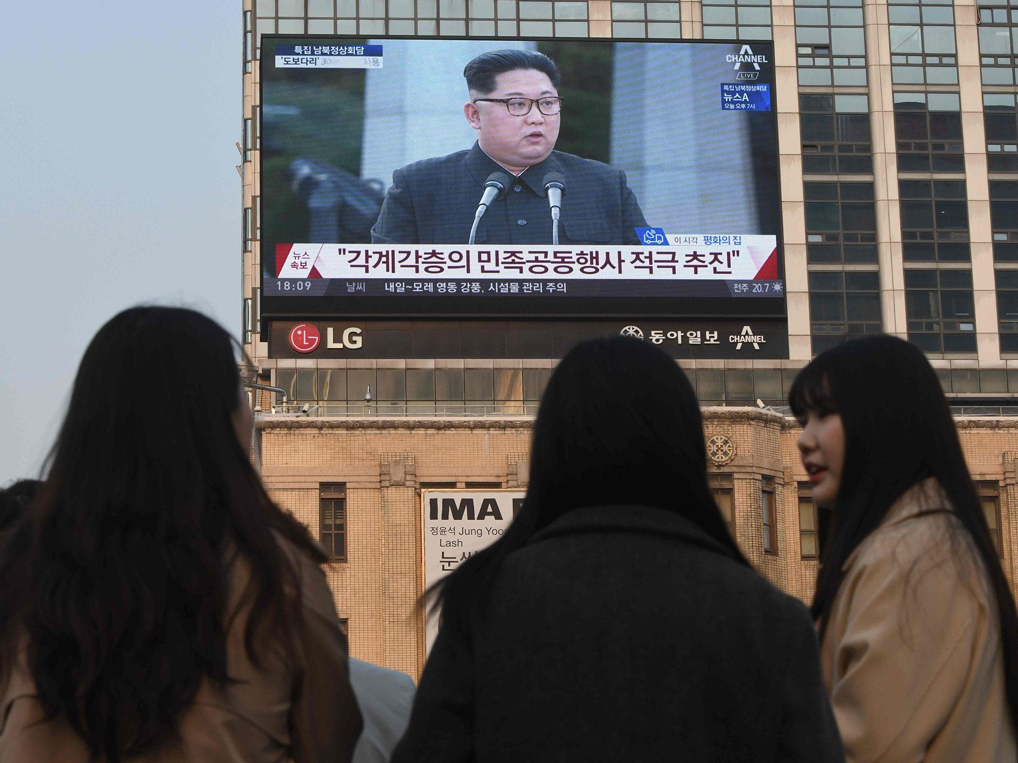 Pedestrians watch the inter-Korean summit on Friday in Seoul