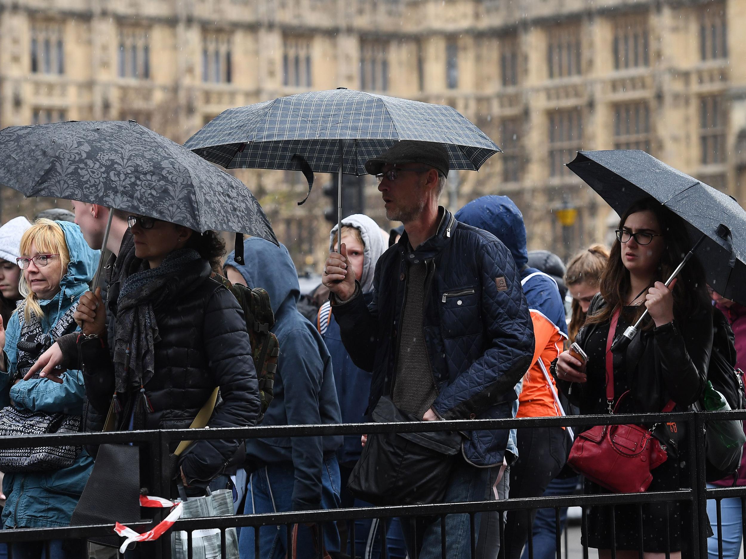 People walk in the rain in London on 25 April