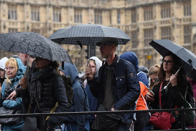 People walk in the rain in London on 25 April