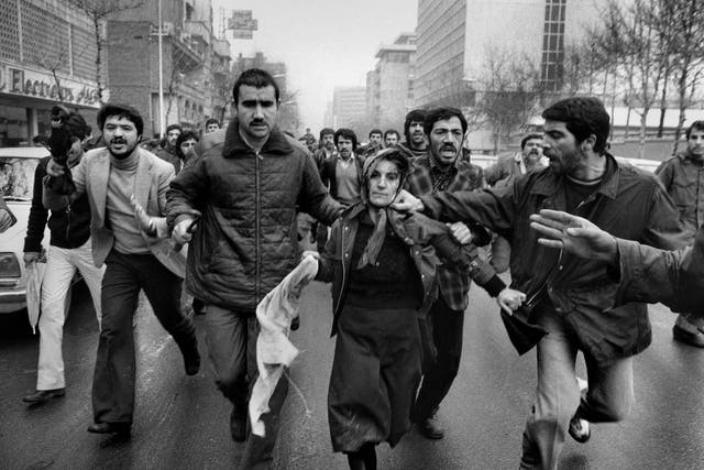 A woman believed to be a supporter of the Shah is assailed by male revolutionaries in Tehran on 25 January 1979