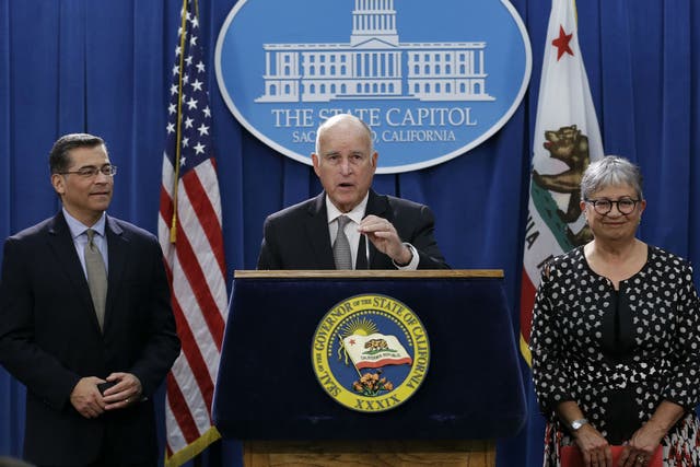 Jerry Brown, flanked by California Attorney General Xavier Becerra California Air Resources Board Chair Mary Nichols, discusses the lawsuit in Sacramento, California