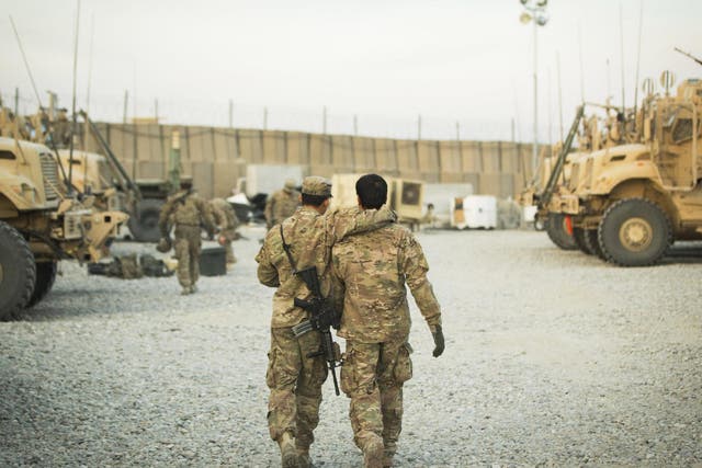 A US soldier walks with an Afghan interpreter before a mission