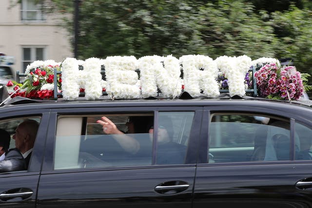 A passenger gestures from a vehicle that forms part of the funeral cortege of burglar Henry Vincent, near St Marys Church in St Mary Cray on 3 May