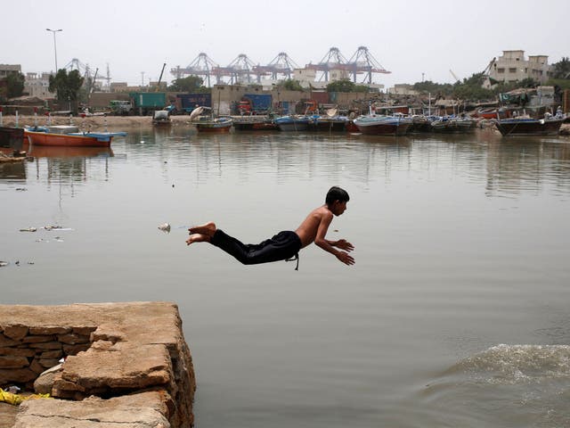 A boy jumps into the water in Karachi to cool off amid the Pakistan heatwave