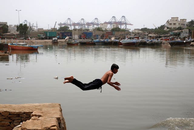 A boy jumps into the water in Karachi to cool off amid the Pakistan heatwave