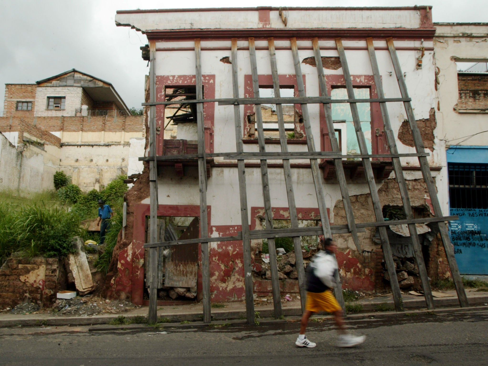 A resident walks past a building destroyed by Hurricane Mitch in Tegucigalpa, Honduras