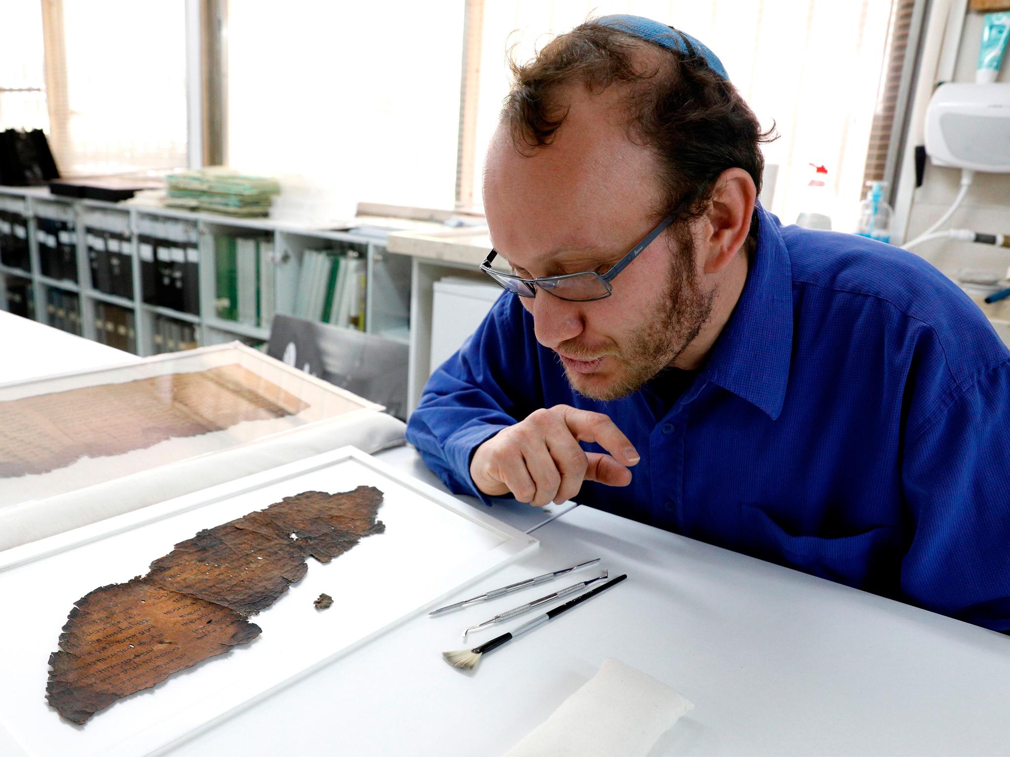 Researcher Oren Ableman examines a fragment of the Dead Sea Scrolls