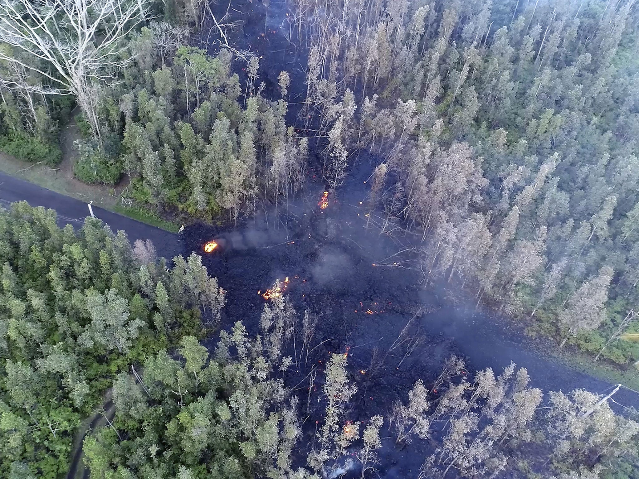 Lava flows over a road in the Puna District as a result of the eruption from Kilauea on Hawaii’s Big Island