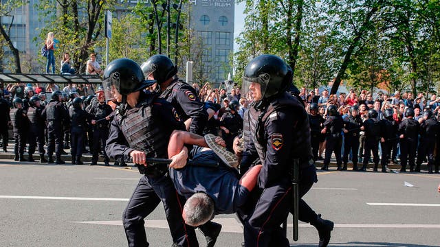 Russian police officers detain a protester in Moscow