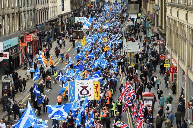Anti-independence supporters wave Union Jack flags as thousands of demonstrators march in support of Scottish independence through the streets of Glasgow.
