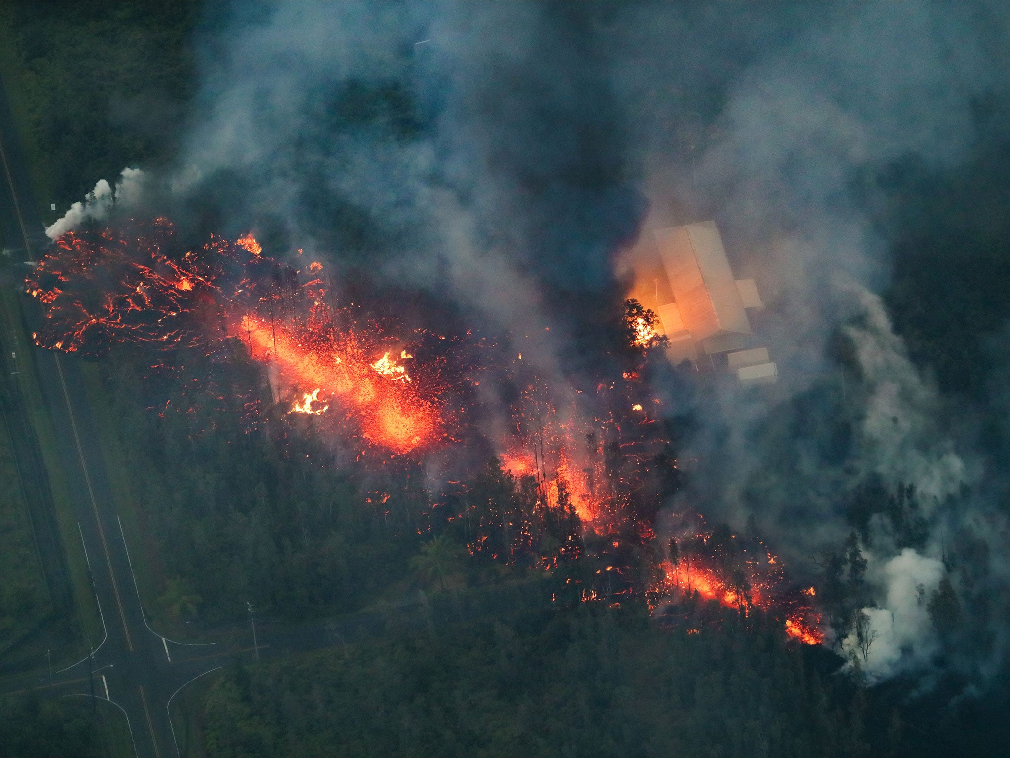 A 2,000 foot long fissure erupts within the Leilani Estates subdivision, on the east rift zone of the Kilauea volcano, igniting a home, and creating a black plume of smoke