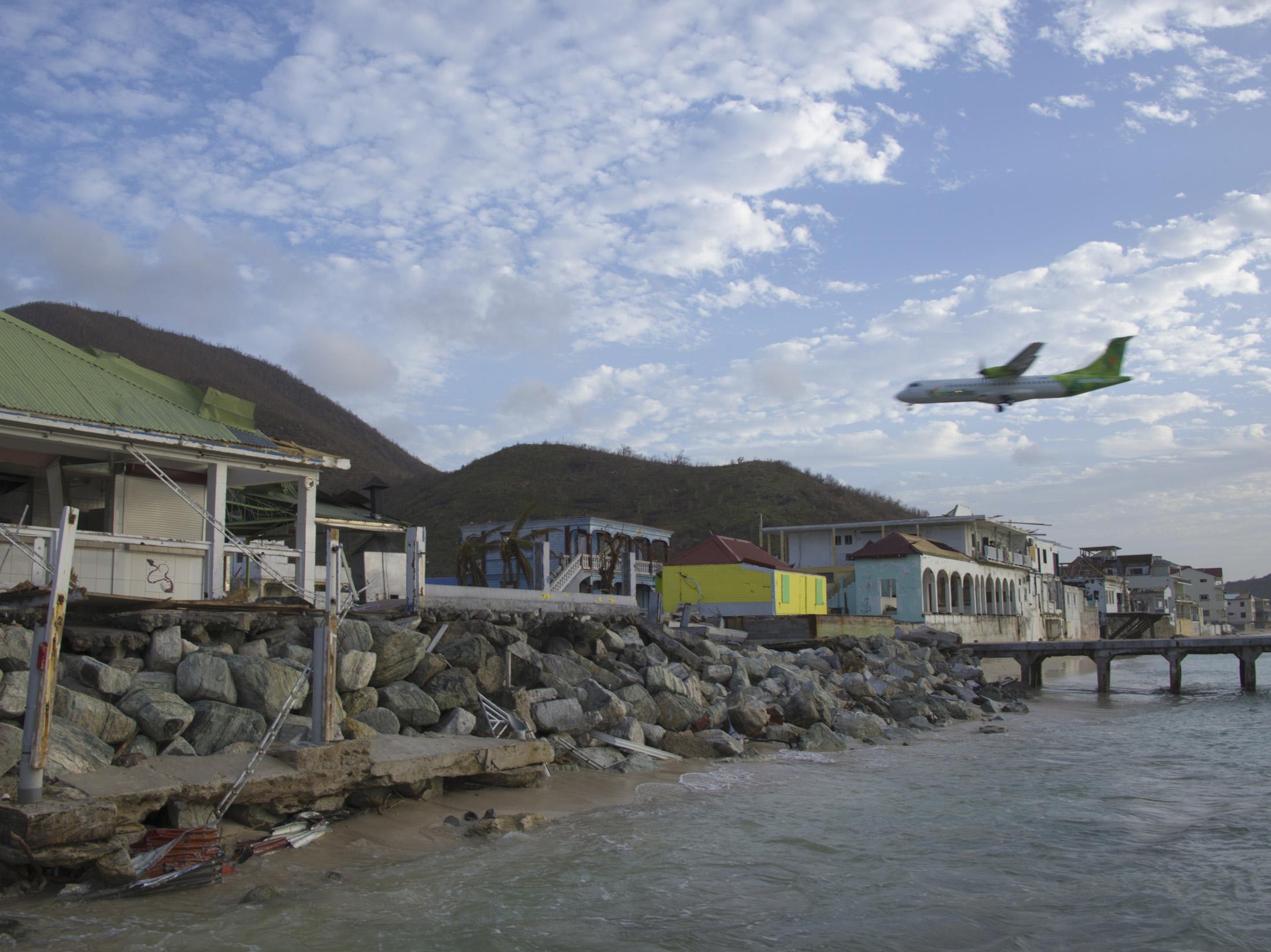 A plane flies over the French Caribbean island of Saint Martin after Hurricane Irma struck in 2017