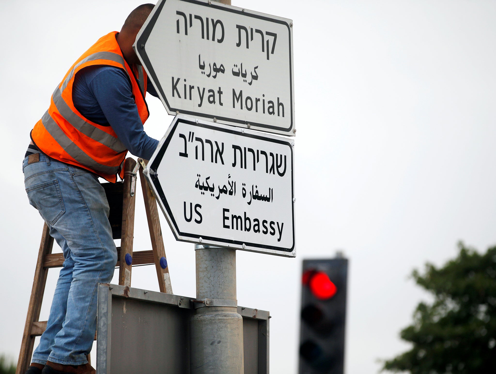 worker hangs a road sign directing to the U.S. embassy in Jerusalem which will open on 14 May