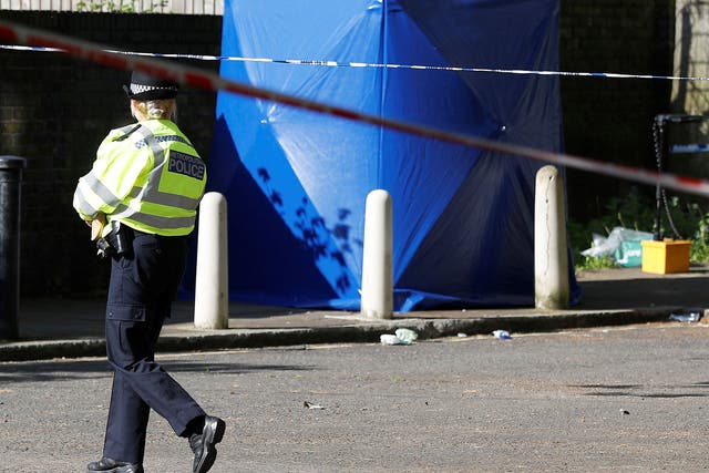 A police officer walks inside a cordon at the scene where a teenager was found after being shot on 5 May in London
