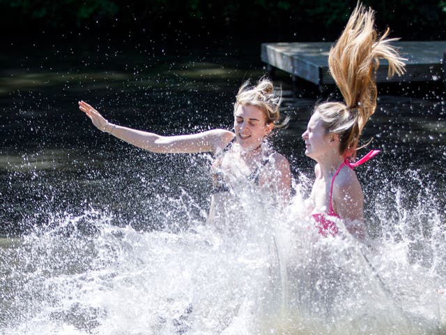 Swimmers take a dip at Hampstead Heath Mixed Bathing Pond in London on Britain's warmest-ever early bank holiday