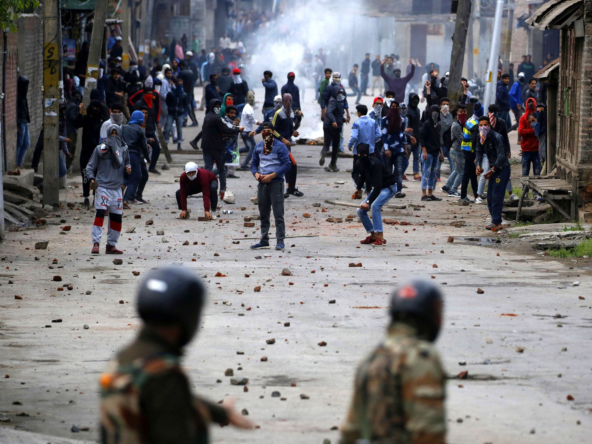 Kashmiri Muslim protesters prepare to throw stones at Indian police and paramilitary men during clashes in downtown area of Srinagar, the summer capital of Indian Kashmir