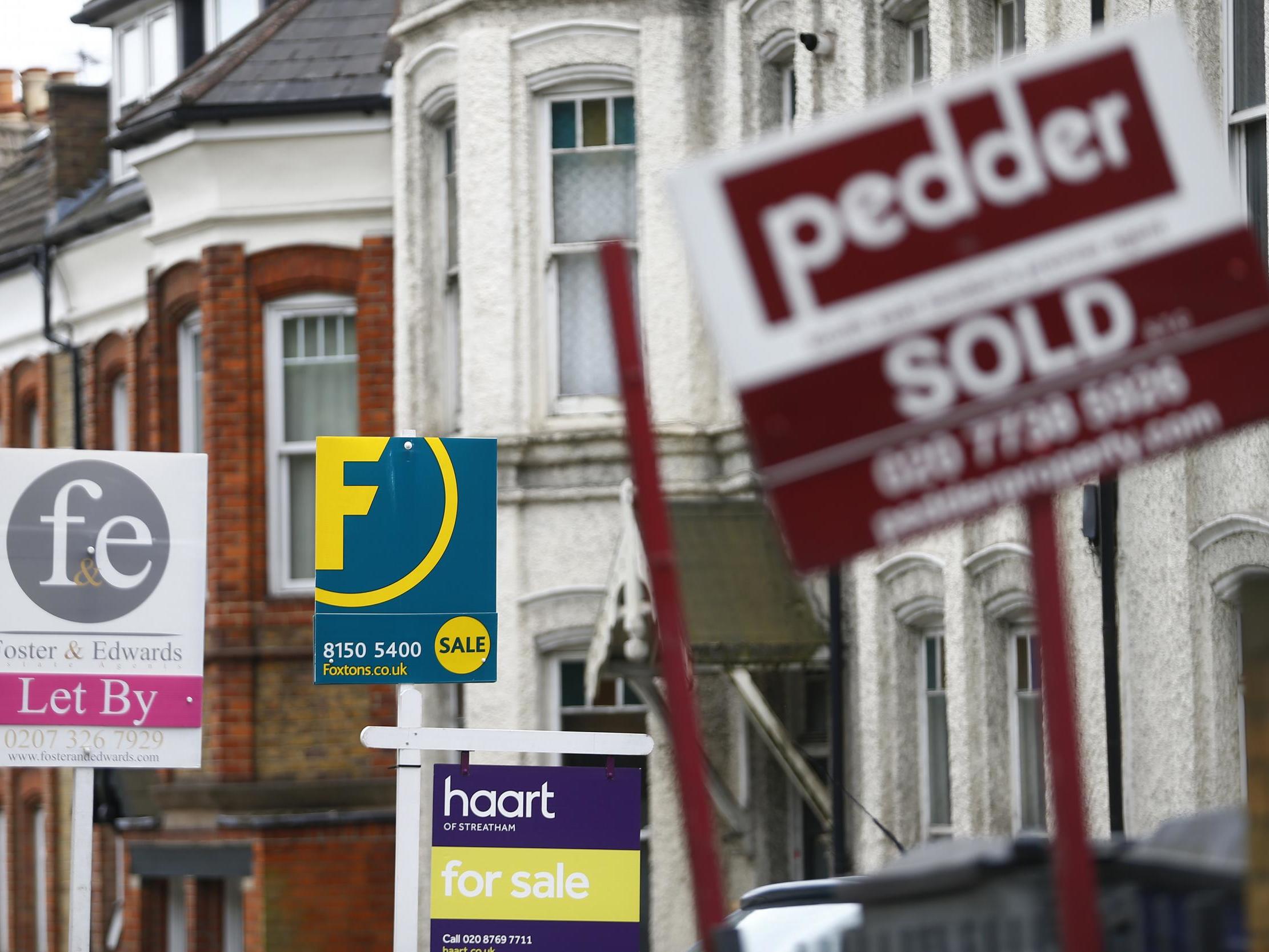 Estate agents boards are lined up outside houses in south London