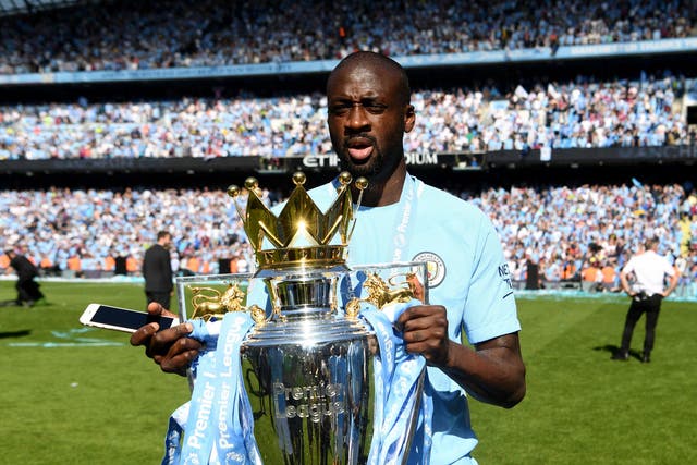 Yaya Toure celebrates with the Premier League trophy