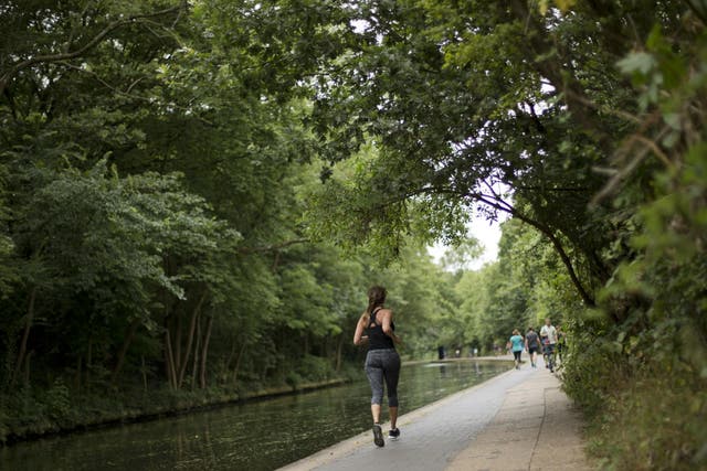 A woman jogs along the Regent's Canal towpath in London