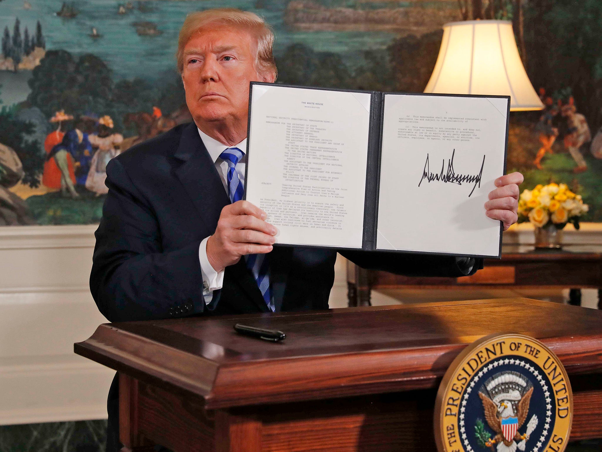 US President Donald Trump displays a presidential memorandum after announcing his intent to withdraw from the Iran nuclear agreement