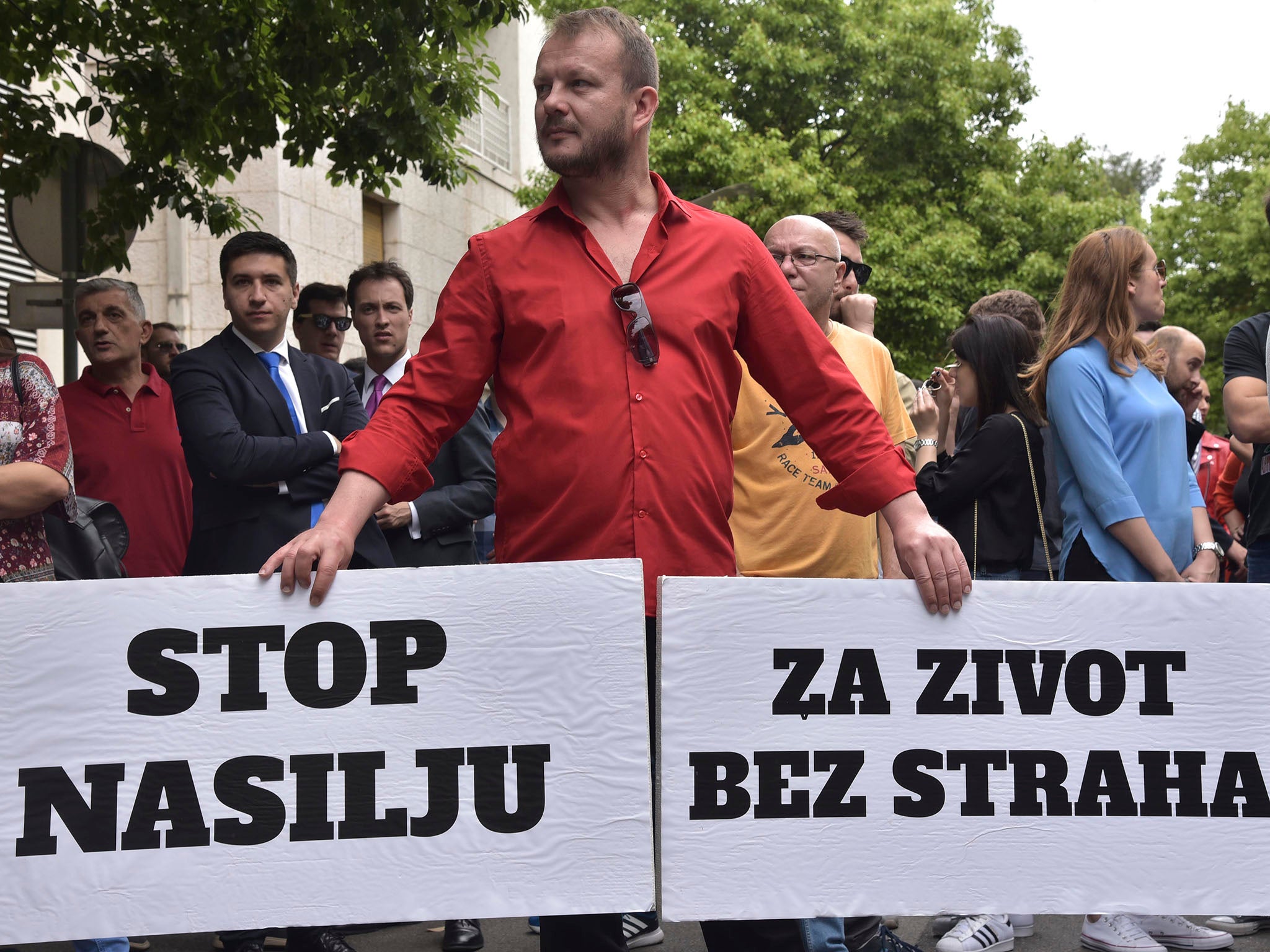 Montenegro man holds banners reading "Stop violence" left, and "For a life without fear" during a protest in Podgorica