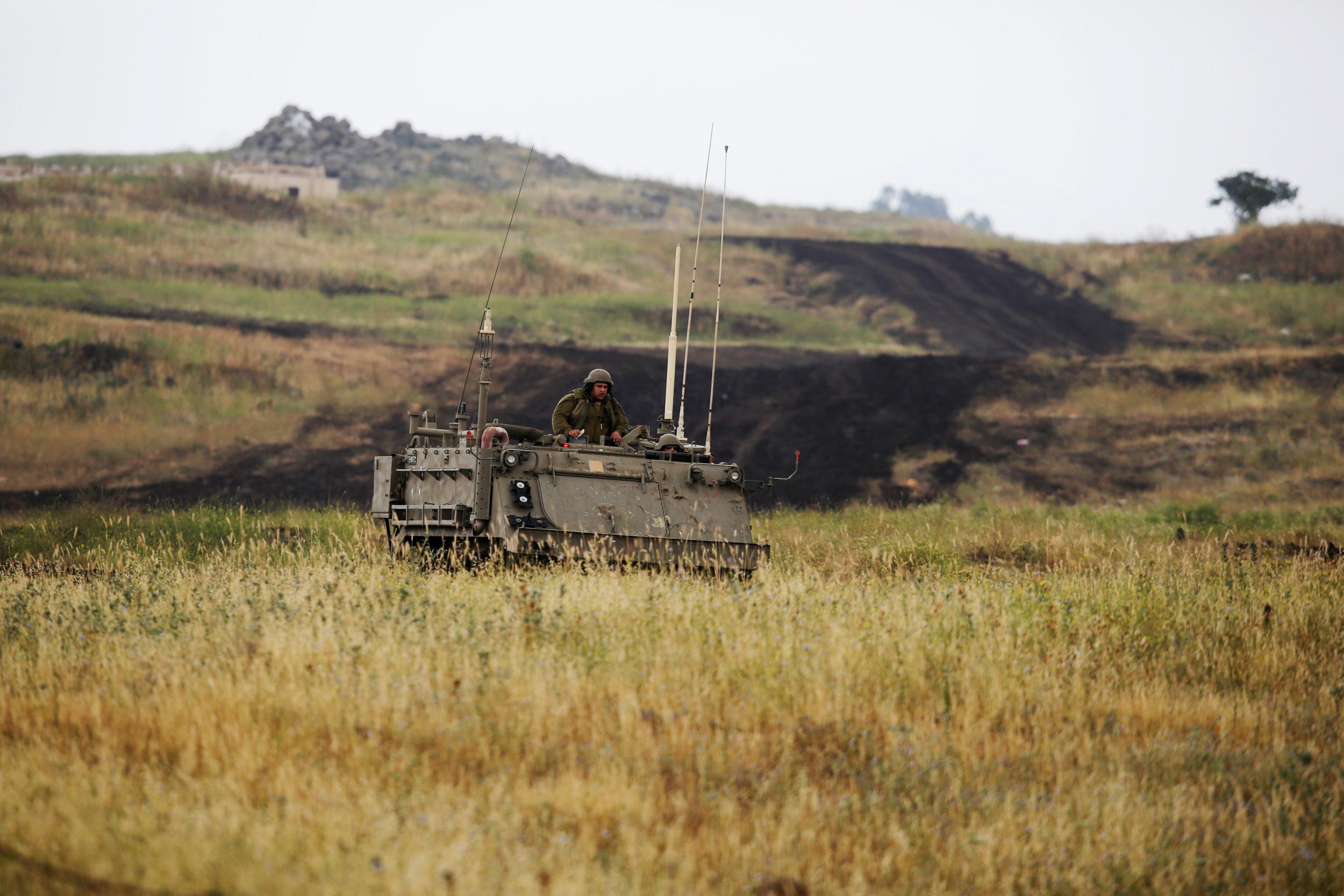An Israeli soldier sits on an armoured vehicle as it drives near the Israeli side of the border with Syria in the Israeli-occupied Golan Heights, Israel 9 May 2018.