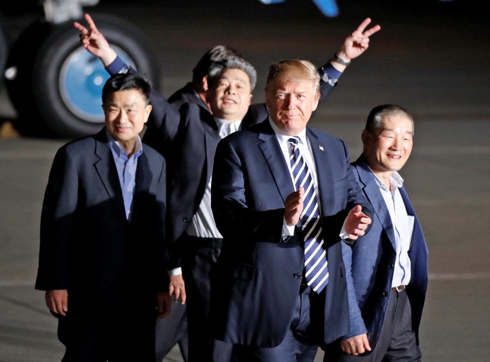 The three Americans formerly held hostage in North Korea next to President Donald Trump upon their arrival at Joint Base Andrews