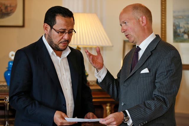 Dominick Chilcott, right, British ambassador in Turkey, hands over a letter of apology from the UK government to Libyan dissident Abdel Hakim Belhaj,  at the British Consulate, in Istanbul