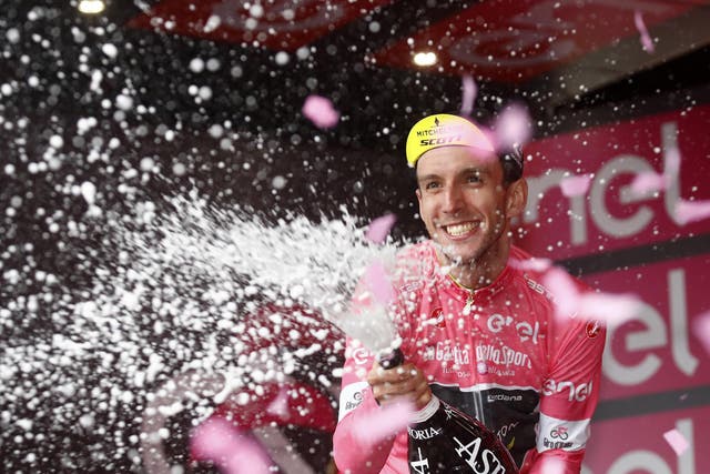 Adam Yates celebrates claiming the pink jersey