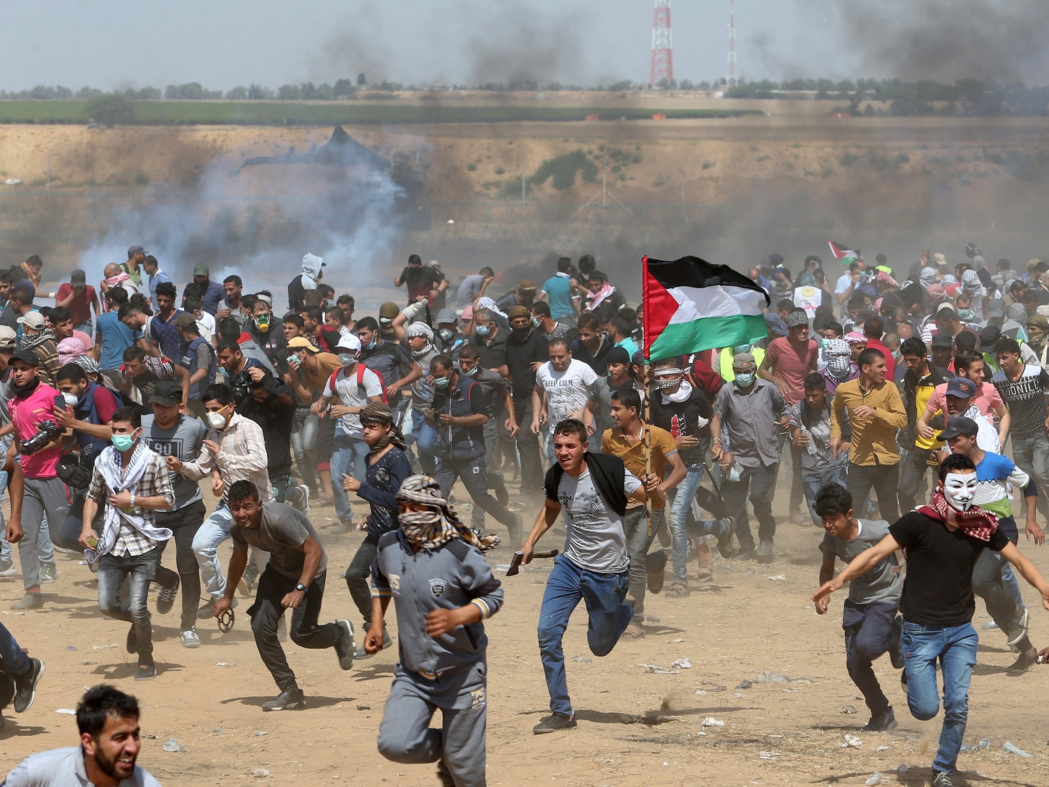 Palestinian demonstrators run from tear gas fired by Israeli forces on Friday