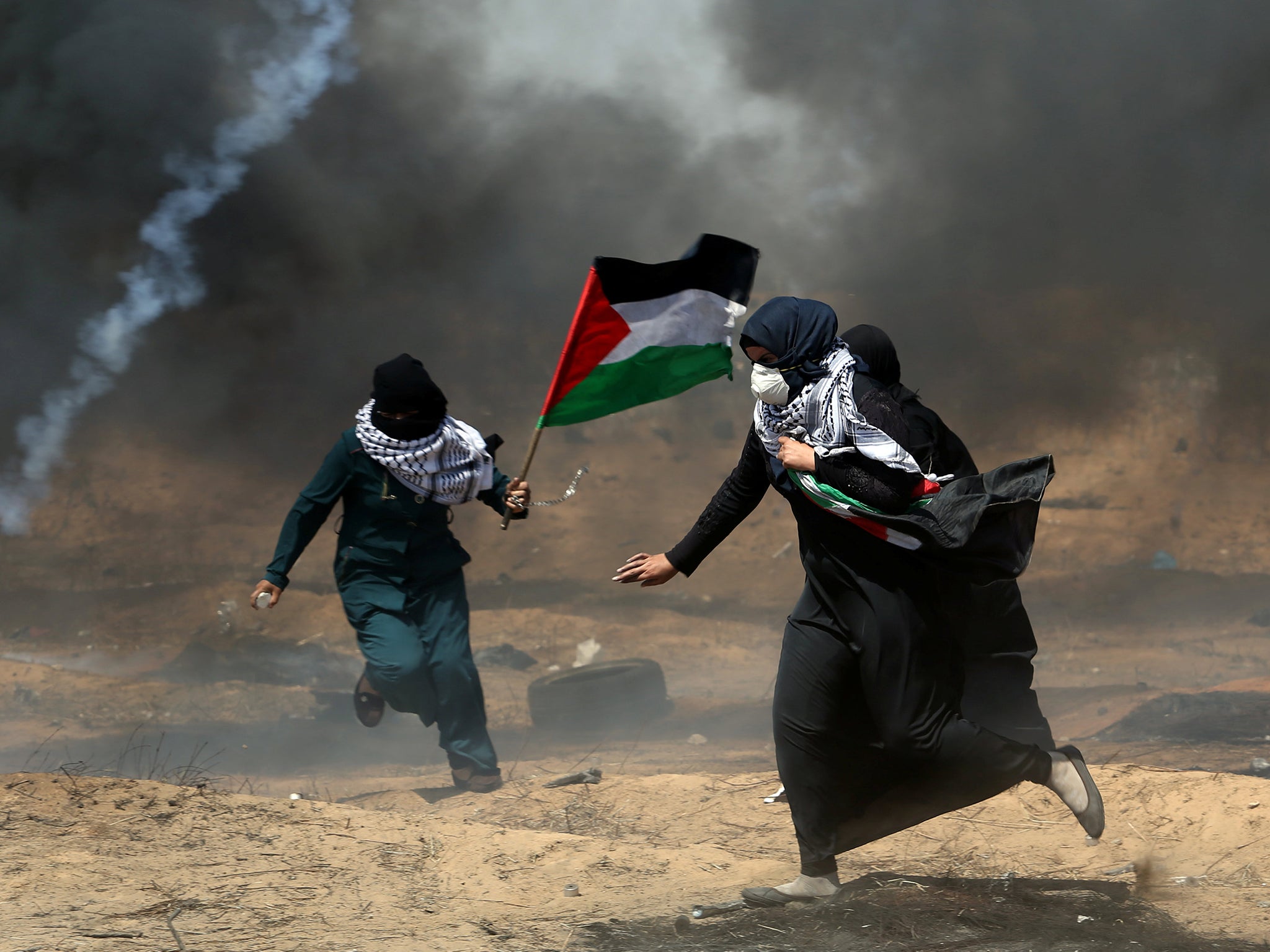 Female demonstrators run for cover from tear gas fired by Israeli forces at a protest on Friday during the Great Return March