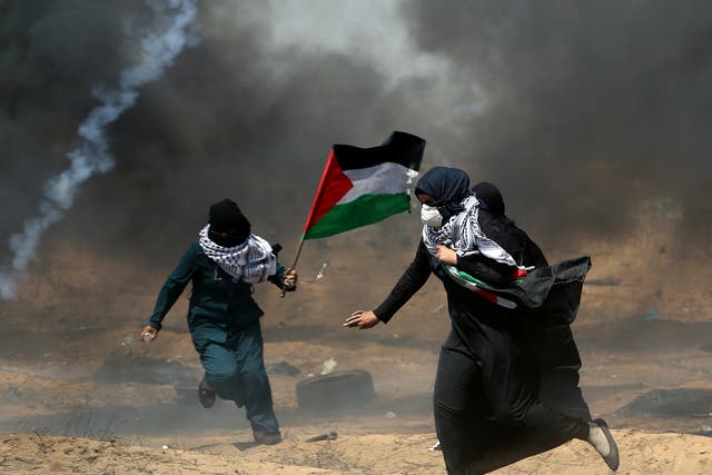 Female demonstrators run for cover from tear gas fired by Israeli forces at a protest on Friday during the Great Return March
