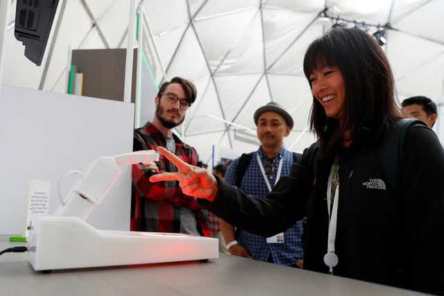 An attendee competes in a game of rock, paper, scissors against a Handbot robot during the annual Google I/O developers conference in Mountain View, California