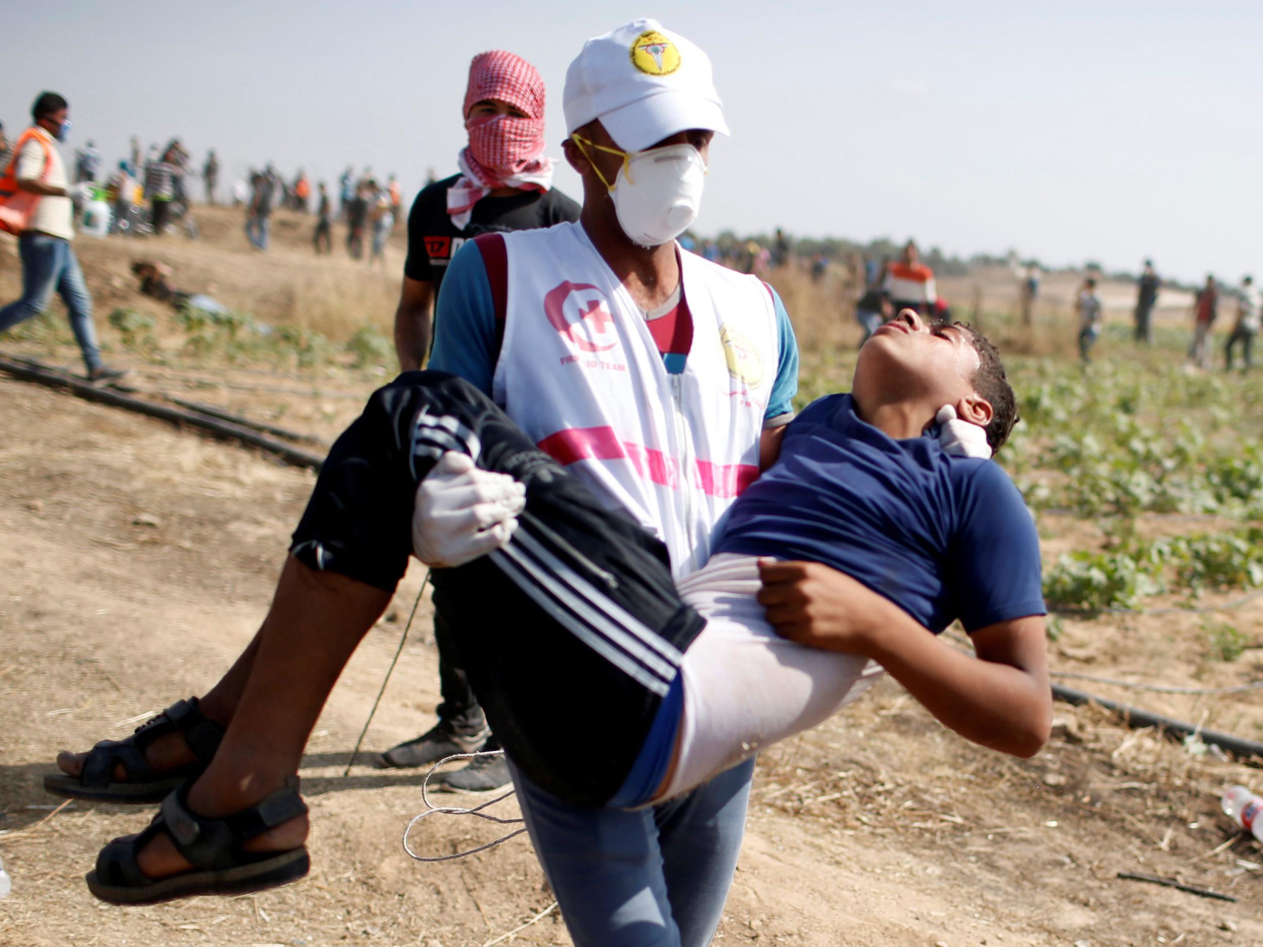 A boy is carried away by a rescue worker during the Gaza protest on Friday