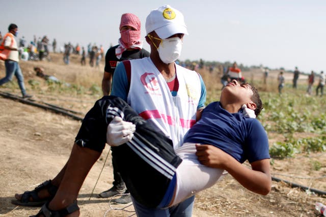 A boy is carried away by a rescue worker during the Gaza protest on Friday