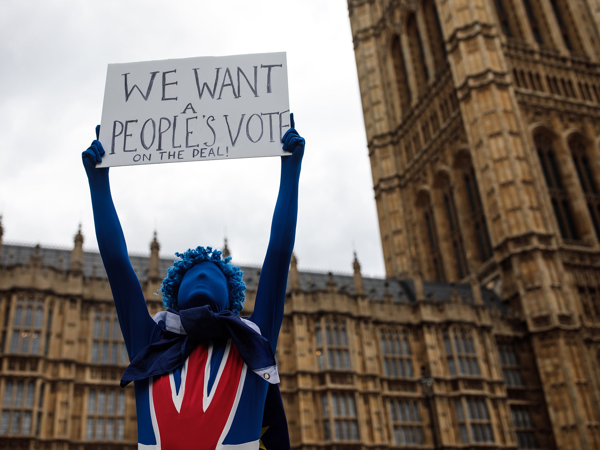 An anti-brexit campaigner holds up a placard during a protest outside the Houses of Parliament