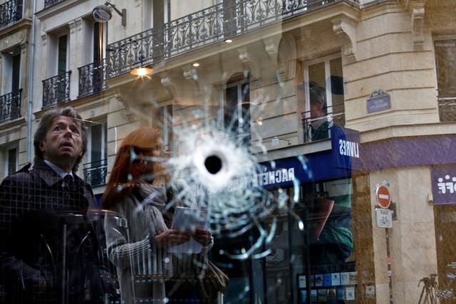 A bullet hole seen on the window of a cafe located near the area where the assailant of a knife attack was shot dead by police officers, in central Paris