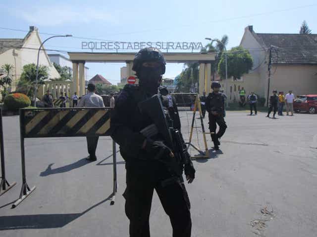 Police stand guard at police headquarters following a suicide attack in Surabaya