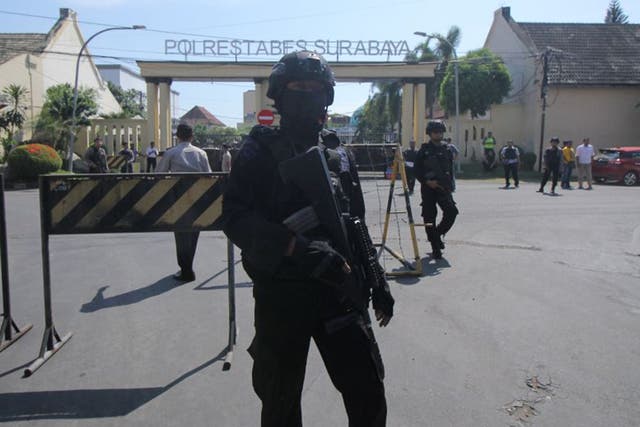 Police stand guard at police headquarters following a suicide attack in Surabaya