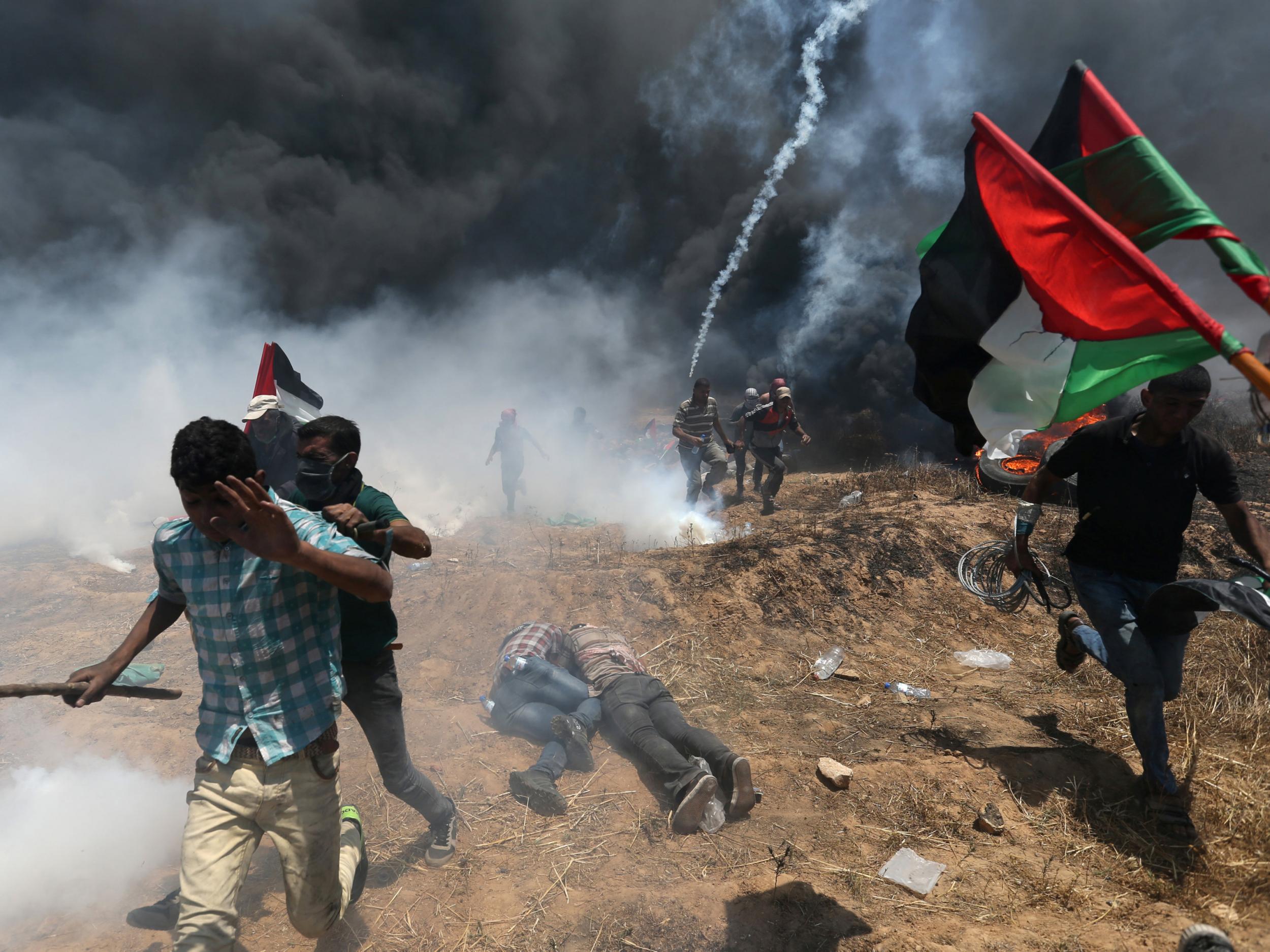 Palestinian protesters flee from Israeli tear gas at a demonstration in May