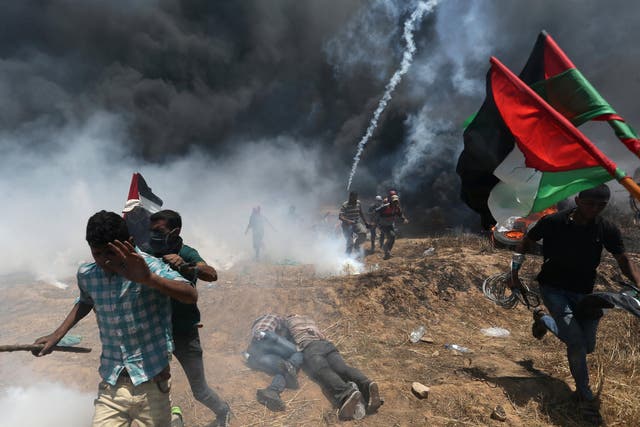 Palestinian protesters flee from Israeli tear gas at a demonstration in May