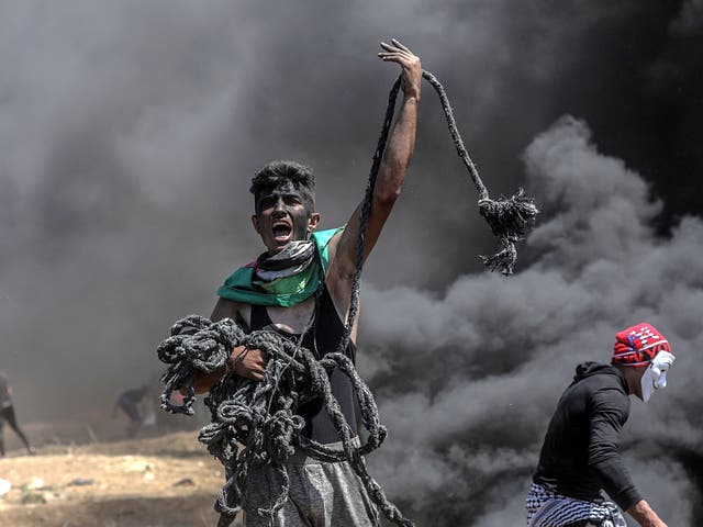 A Palestinian protester holds a rope during protests near the border with Israel