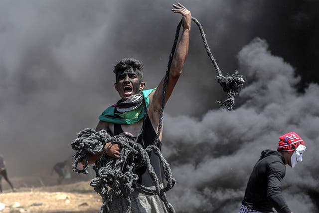 A Palestinian protester holds a rope during protests near the border with Israel