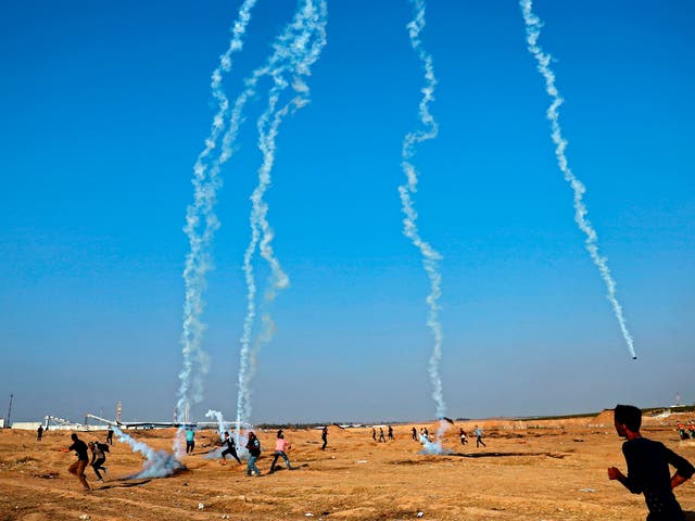 Palestinians run to take cover as an Israeli drone fires tear gas grenades east of Gaza City