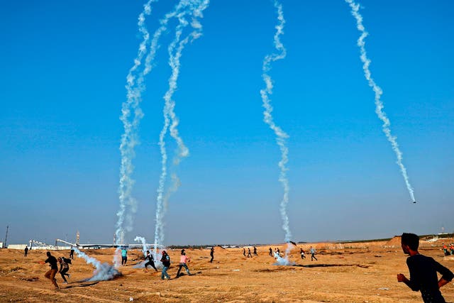 Palestinians run to take cover as an Israeli drone fires tear gas grenades east of Gaza City